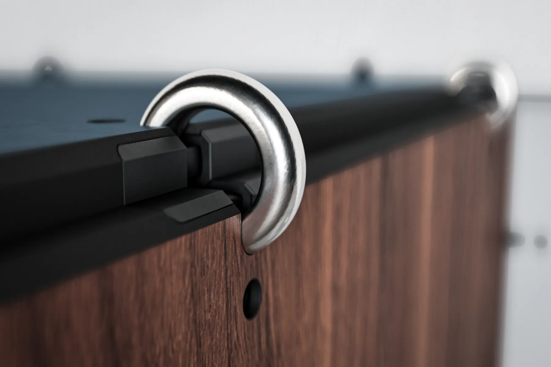 Detail of the stainless steel Anillo ring connector on a walnut front