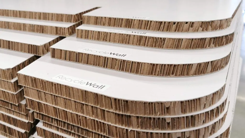 Gestapelte Platten aus recyclebarem Wabenkarton mit RecycleWall-Logo